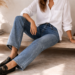 Woman wearing a white Oxford shirt styled with straight-leg jeans and black loafers, showing a relaxed polished everyday outfit.