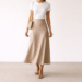 Woman wearing a neutral midi skirt outfit showing the mid-calf skirt length, styled with a simple top and sandals.