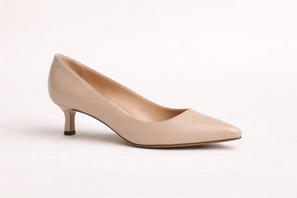 Single women’s kitten heel shoe on neutral background showing a low elegant heel style.